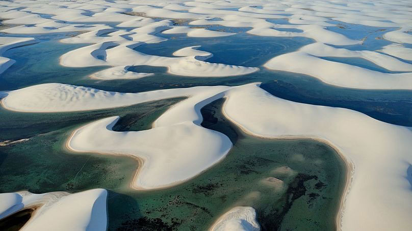 The otherworldly landscape of Lençóis Maranhenses is best enjoyed in July, when visitors can swim its blue lagoons.Canva