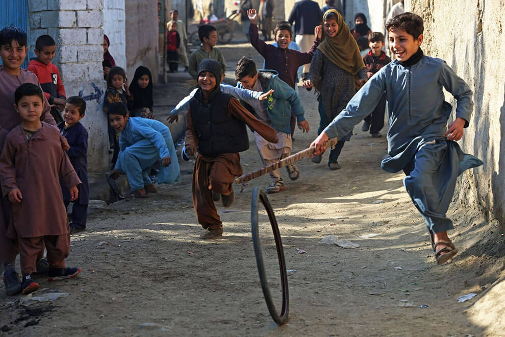 کودکان در ۹ ژانویه ۲۰۲۳ در امتداد خیابانی در جلال آباد افغانستان با لاستیک بازی می‌کنند.